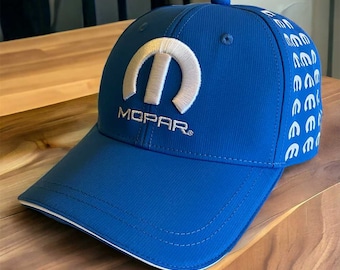 Może przedstawiać: Niebieska czapka z daszkiem z białym logo Mopar i białymi logo Mopar powtarzającymi się po bokach.