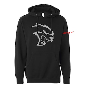 May include: Black hooded sweatshirt featuring a silver snarling cat face graphic on the front. The word "SRT" is printed in red on the right sleeve. The sweatshirt has a front pocket and a drawstring hood.