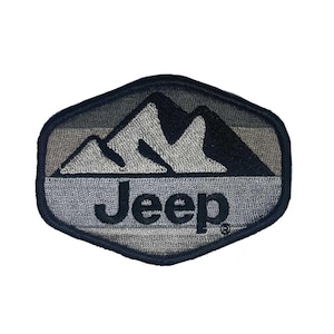 Puede incluir: Un parche bordado en negro y gris con una cordillera y la palabra "Jeep" en letras negras.