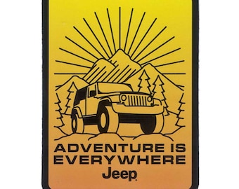 Puede incluir: Una pegatina amarilla y negra con un logotipo de Jeep y el texto "La aventura está en todas partes". La pegatina presenta una ilustración en blanco y negro de un Jeep conduciendo por un paisaje montañoso con un sol brillando arriba.