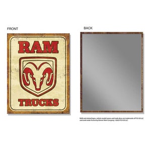 Pode incluir: Placa retangular com a palavra "RAM" em vermelho, acima de um logotipo de carneiro vermelho, e a palavra "TRUCKS" em vermelho. A placa tem um visual desgastado e vintage com uma borda marrom. A parte de trás da placa é um espelho.