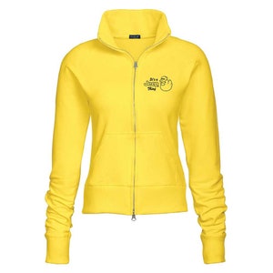May include: A bright yellow zip-up sweatshirt with a high collar and long sleeves. The sweatshirt features a small black graphic and the text "It's a Jeep Thing" on the upper left chest. The jacket has a front pocket and ribbed cuffs.