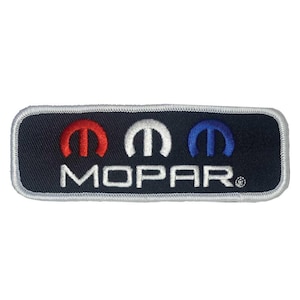 May include: Embroidered patch featuring the MOPAR logo. The patch has a navy blue background with a white border. The logo includes three stylized 'M' symbols in red, white, and blue, with the word "MOPAR" in white below.