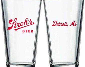 May include: Two clear glass pint glasses with red lettering. One glass says "Strohs' Beer" and the other says "Detroit, Mi".