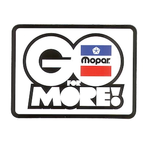 Puede incluir: Una pegatina rectangular con borde negro y las palabras "GO FOR MORE!" en letras blancas en negrita. El "GO" está formado por dos círculos conectados. El logotipo de Mopar está en el centro.