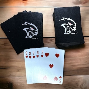 May include: A deck of playing cards with a black and white graphic of a snarling animal with the text "SRT" on the back of the cards. The front of the cards show the numbers 5, 6, 7, 8, and 9 of hearts.