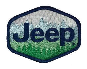 Op de afbeelding: Een blauw en groen geborduurd patch met het woord "Jeep" op een witte achtergrond. De patch toont een gestileerde afbeelding van een bos.