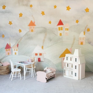 Könnte beinhalten: Ein weißes Puppenhaus mit einem rosafarbenen Dach und einem Balkon, ein rosa Puppenbett, ein weißer Tisch und Stühle und ein Teddybär, der am Tisch sitzt. Der Hintergrund ist eine hellblaue und grüne Tapete mit einem Muster aus Sternen und Häusern.