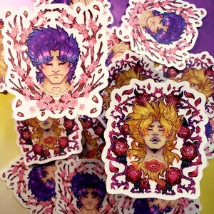Puede incluir: Una colección de pegatinas de estilo anime con retratos de personajes. Una pegatina muestra un personaje con cabello morado enmarcado por flores de cerezo. Otra representa un personaje con cabello rubio rodeado de rosas y espinas. Las pegatinas tienen un borde blanco.