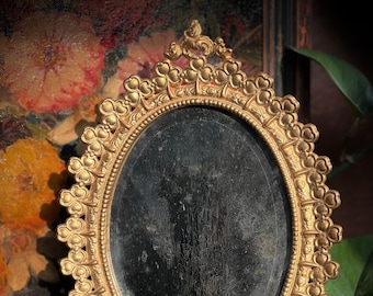 Vanity Mirror with Three Leaf Clover Ornate Brass Frame and Distressed Beveled Oval Mirror with Easel Stand