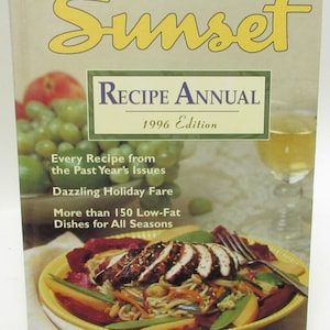 May include: The cover of Sunset Magazine's 1996 Recipe Annual cookbook features a yellow plate with a colourful salad with chicken and noodles. The text on the cover reads "Sunset Recipe Annual 1996 Edition" and "Every Recipe from the Past Year's Issues, Dazzling Holiday Fare, More than 150 Low-Fat Dishes for All Seasons."