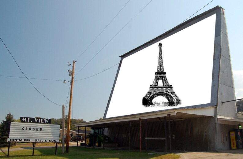 May include: A drive-in movie theater with a large billboard displaying a black and white image of the Eiffel Tower. The billboard reads "MT. VIEW CLOSED OPEN FRI, SAT, & SUN."