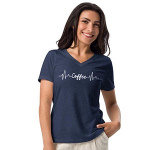 May include: A navy blue V-neck t-shirt with the word "Coffee" in a white heartbeat design. The shirt is made of a soft material.
