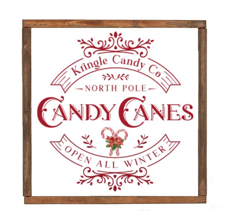 May include: A white sign with a red border and red text that reads "Kringle Candy Co. - North Pole - Candy Canes Open All Winter". The sign has a decorative border and a candy cane illustration.