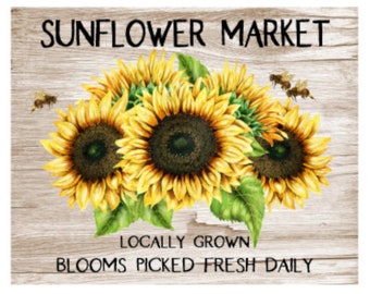 May include: A rustic wooden sign with the text "Sunflower Market" in black lettering. The sign features a cluster of yellow sunflowers with green leaves and a few bees flying around them. The text "Locally Grown" and "Blooms Picked Fresh Daily" is also displayed on the sign.