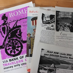 May include: A stack of vintage travel advertisements. One features a pink and black image of a Roman chariot with the text "ROME" and "VIA BANK OF A TRAVELERS C". Other ads promote Alaska and Oregon vacations, with black and white images and text.