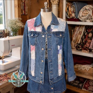 May include: A blue denim jacket featuring quilted panels on the front chest and sides. The quilted sections display a patchwork star pattern in red, white, and blue fabric. The jacket has a classic collar, metal button closures, and two chest pockets.