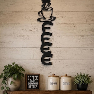 May include: Black metal wall art spelling "Coffee" with a coffee cup design. A wooden shelf holds a potted plant, a sign that reads "Coffee makes everything better", and two ceramic jars labeled "Coffee" and "Sugar".