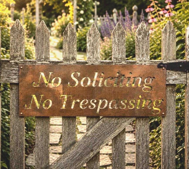 May include: A rectangular metal sign with a rusted finish mounted on a weathered wooden picket fence. The sign features laser-cut lettering that reads No Soliciting and No Trespassing in a clear, bold font, secured by screws at the corners.