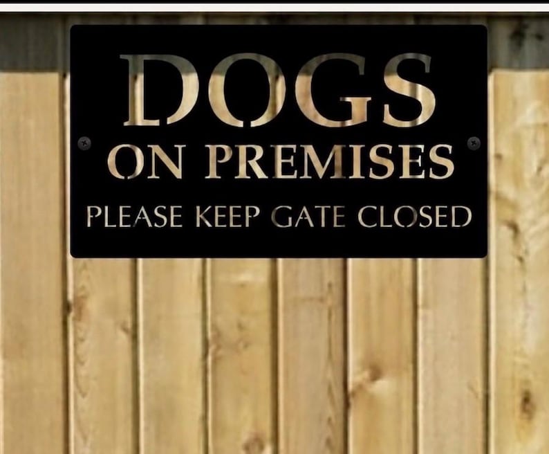 Pu&ograve; includere: Una targa rettangolare in metallo nero con scritte color oro metallizzato che recita DOGS ON PREMISES e PLEASE KEEP GATE CLOSED. La targa presenta due piccole viti nere, una nell'angolo superiore sinistro e una nell'angolo destro.