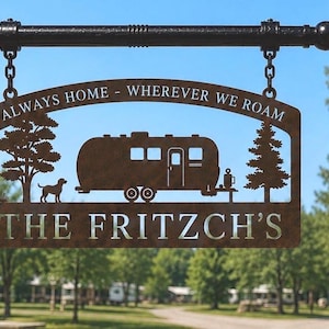 Puede incluir: Un letrero colgante de metal color &oacute;xido suspendido de una barra negra mediante dos cadenas. El letrero presenta un dise&ntilde;o recortado de una caravana, un perro y dos &aacute;rboles. El texto "ALWAYS HOME - WHEREVER WE ROAM" y "THE FRITZCH'S" est&aacute; recortado.
