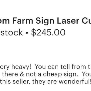 May include: A black laser-cut metal sign featuring the text BROWNLEIGH FARMS in a curved arch above a central graphic of a barn and silo, with a decorative scrollwork border and a horizontal hanging bar at the top of the rectangular structure.