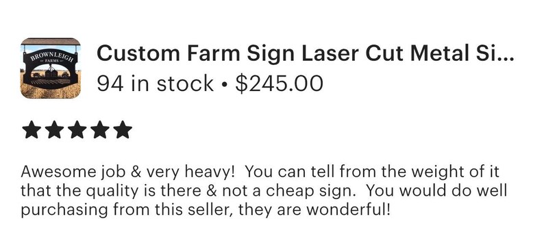 May include: A black laser-cut metal sign featuring the text BROWNLEIGH FARMS in a curved arch above a central graphic of a barn and silo, with a decorative scrollwork border and a horizontal hanging bar at the top of the rectangular structure.