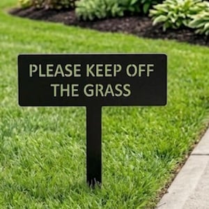 Può includere: Un cartello da giardino rettangolare in metallo nero con la scritta PLEASE KEEP OFF THE GRASS in un carattere in stile stencil. Il cartello è montato su un unico paletto verticale, posizionato in verticale su un prato verde.