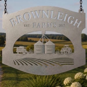 May include: A silver-colored metal hanging sign featuring the text "BROWNLEIGH FARMS EST. 2017" cut out from the top. The center displays a detailed silhouette of two grain silos, a tractor, and a combine harvester above a field of rows.