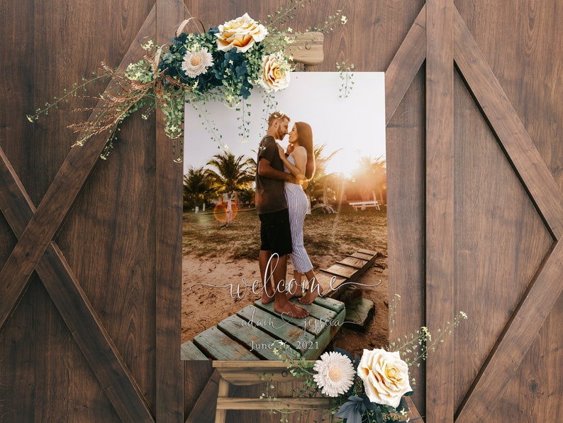 May include: A wedding welcome sign with a photo of a couple on a beach. The sign says "Welcome" with the couple's names and wedding date: June 26, 2021.