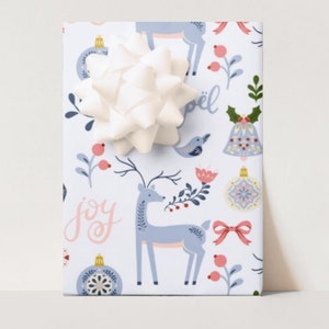 May include: A wrapped gift with a white bow. The wrapping paper features a festive pattern with deer, ornaments, and floral elements in blue, pink, and green on a white background. The word "joy" is visible.