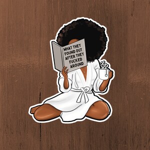 Może przedstawiać: Naklejka przedstawiająca kresk&oacute;wkową ilustrację osoby o ciemnej sk&oacute;rze i dużej afro, czytającej książkę. Na okładce książki widnieje napis "WHAT THEY FOUND OUT AFTER THEY FUCKED AROUND". Osoba ma na sobie biały szlafrok i trzyma filiżankę herbaty.