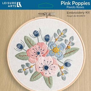May include: Pink Poppies embroidery kit with a wooden embroidery hoop, floss, fabric, needles, and instructions. The kit includes a design of pink poppies and blue flowers.