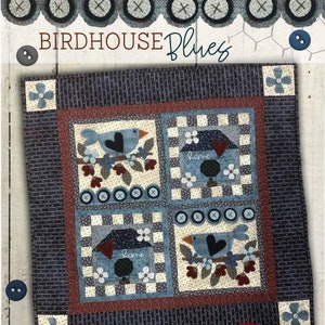 May include: A blue and white quilt with a patchwork design featuring birds, birdhouses, and the word "home". The quilt is framed with a dark blue border and has a title that reads "Birdhouse Blues".