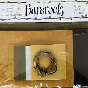 May include: A craft kit for a candle mat, featuring various felt pieces in shades of gold, brown, green, and white, along with embroidery floss. The packaging includes the text "BareRoots" and "#164 Beeskep Candle Mat".