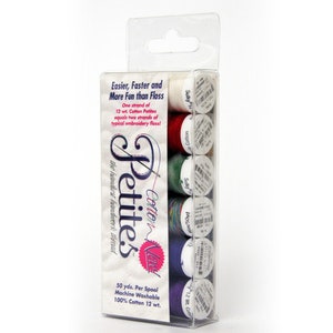 May include: A package of six spools of Cotton & Silk Petites embroidery thread. The spools are in a variety of colors, including white, red, green, blue, and purple. The package is labeled with the brand name "Petites" and the text "Easier, Faster and More Fun than Floss".