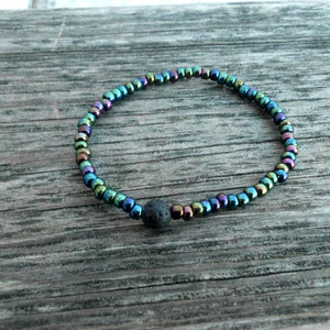 May include: A black lava stone bead bracelet with iridescent black beads.