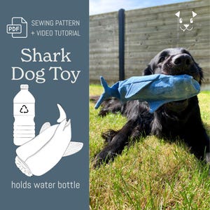 Op de afbeelding: Een zwarte hond die een blauw, haai-vormig hondenspeeltje in zijn bek heeft, liggend op groen gras. De afbeelding bevat de tekst "Shark Dog Toy" en "Sewing Pattern + Video Tutorial". Een afbeelding toont een waterfles en een haai.