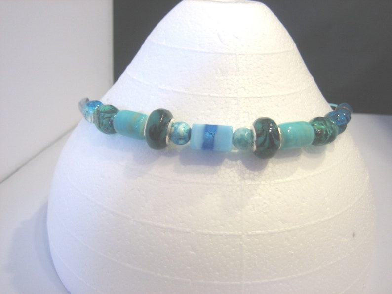Teal glass bead choker on teal aluminum wire.