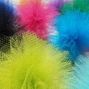 May include: A collection of colorful tulle pom-poms in shades of black, pink, blue, green, and yellow. The pom-poms are made of soft, delicate tulle and are perfect for adding a touch of whimsy to any occasion.