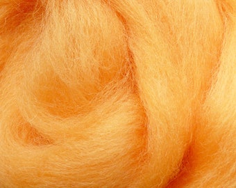 May include: A close-up of a pile of orange wool roving. The wool is soft and fluffy, and it is perfect for felting or spinning.