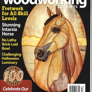 May include: A woodworking magazine cover featuring a detailed wooden horse head. The magazine title is "Scroll Saw Woodworking & Crafts". Text includes "Fretwork", "Intarsia Horse", and "Halloween Luminary". The cover celebrates the 100th issue.