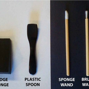 May include: A black wedge sponge, a black plastic spoon, a white sponge wand with a wooden handle, and a white brush wand with a wooden handle.