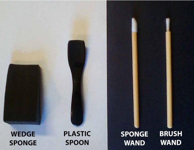 May include: A black wedge sponge, a black plastic spoon, a white sponge wand with a wooden handle, and a white brush wand with a wooden handle.