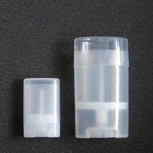 May include: Two clear plastic containers for deodorant or lip balm. The larger container is about 2 inches tall and the smaller container is about 1 inch tall.