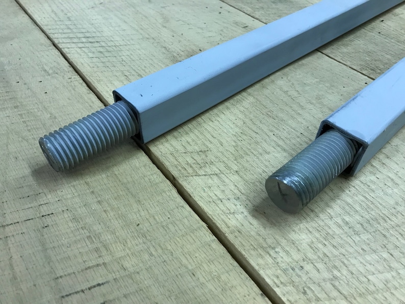 May include: Two metal rods with threaded ends. The rods are painted white and have a square cross-section.