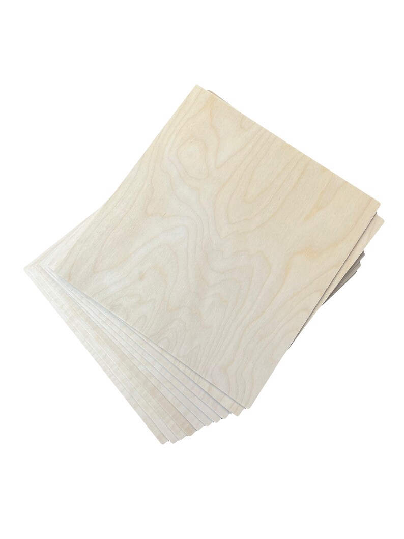Puede incluir: Una pila de hojas de madera sin terminar de color claro. La veta de la madera es visible, con patrones arremolinados en tonos beige y marr&oacute;n. Las hojas son rectangulares y parecen estar listas para manualidades u otros proyectos.