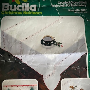 K&ouml;nnte beinhalten: Bucilla Christmas Heirloom gez&auml;hlte Kreuzstich-Tischdecke zum Sticken, misst 152,4 x 274,3 cm. Die wei&szlig;e Tischdecke hat einen rot-gr&uuml;nen gestickten Rand mit Weihnachtsbaum-Designs. Enth&auml;lt ein Set mit vier Servietten.