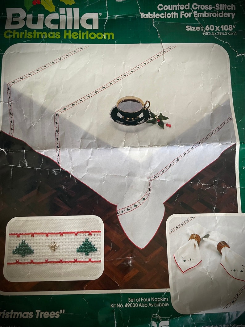 K&ouml;nnte beinhalten: Bucilla Christmas Heirloom gez&auml;hlte Kreuzstich-Tischdecke zum Sticken, misst 152,4 x 274,3 cm. Die wei&szlig;e Tischdecke hat einen rot-gr&uuml;nen gestickten Rand mit Weihnachtsbaum-Designs. Enth&auml;lt ein Set mit vier Servietten.