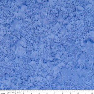 May include: Blue fabric with a marbled, swirled pattern. The fabric has a subtle texture and a light blue color.